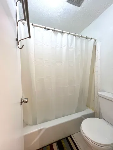 a view of a white building among the street with houses