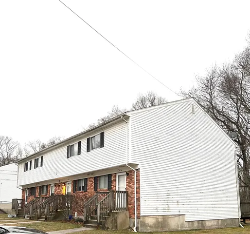 a front view of a house with a large tree