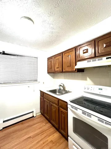 a kitchen with stainless steel appliances granite countertop a sink and a stove