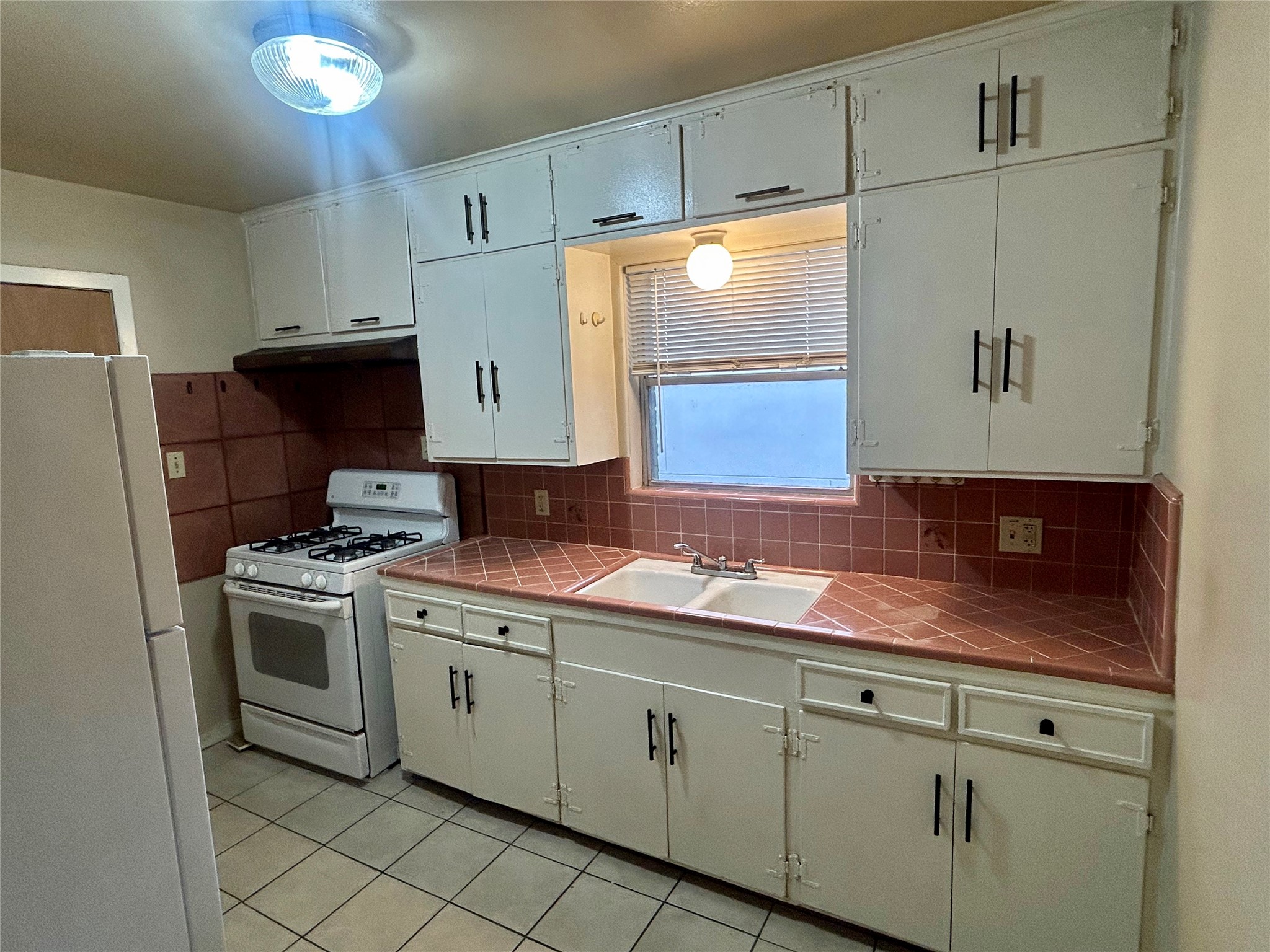 1411 Indiana Street, Unit 5 Houston, TX 77006 - Photo 5 of 14 a kitchen with cabinets and white appliances