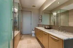 a bathroom with a granite countertop sink a mirror and a bathtub
