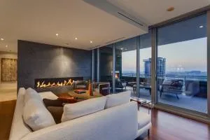 a living room with couches chairs and large view with kitchen view