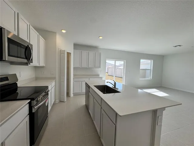a kitchen with stainless steel appliances a sink stove and microwave