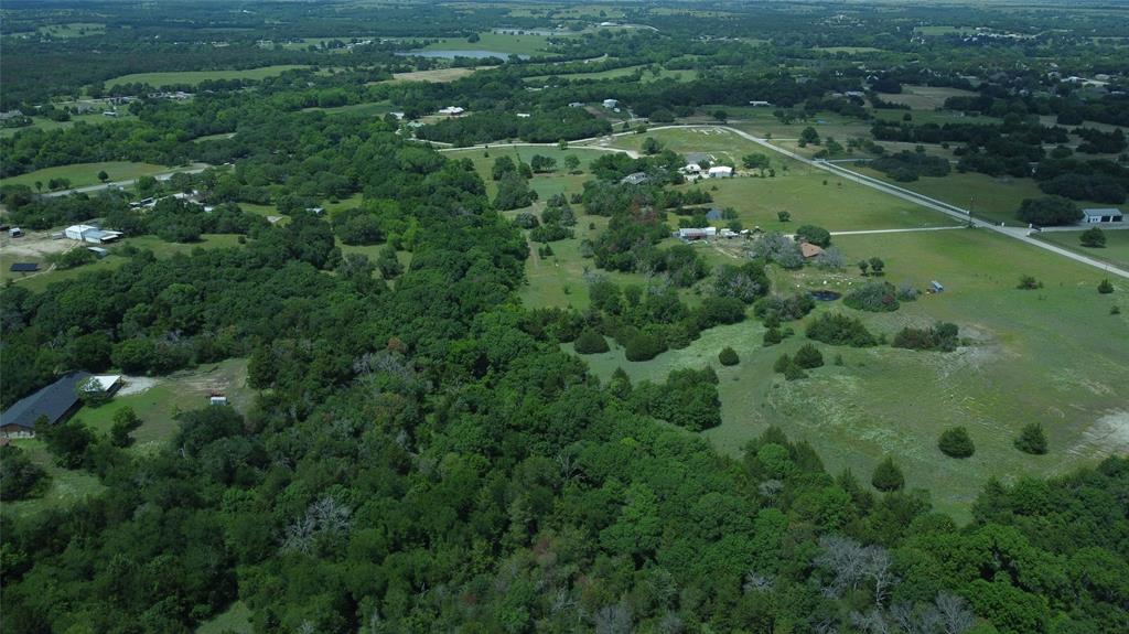 an aerial view of residential houses with outdoor space and trees