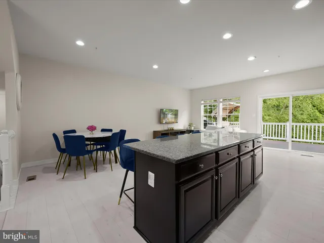 a kitchen with a dining table chairs and a refrigerator