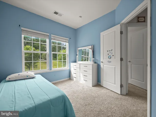 a spacious bedroom with a bed and a dresser