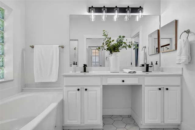 a bathroom with a tub sink and mirror