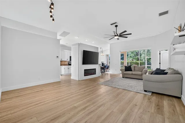 a living room with furniture a flat screen tv and a large window