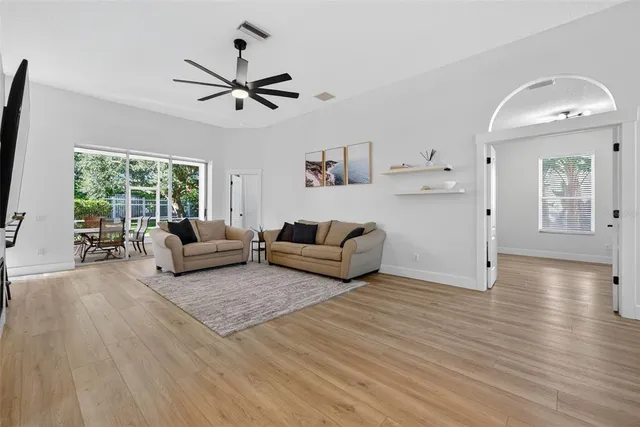 a living room with furniture and a flat screen tv with kitchen view