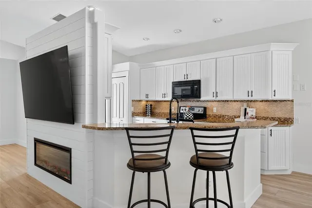 a kitchen with stainless steel appliances granite countertop a sink and wooden cabinets