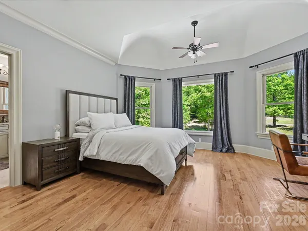 a bed sitting in a spacious bedroom next to a window