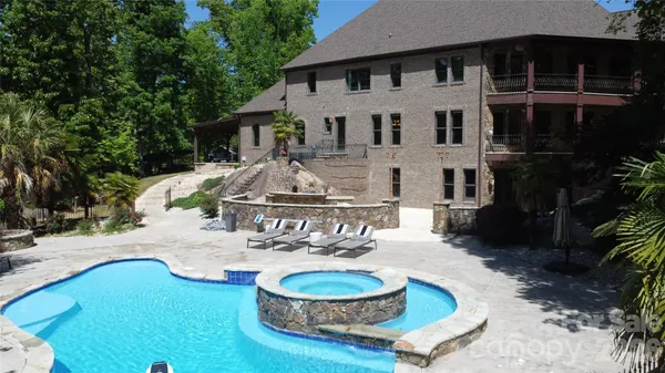 a view of a house with backyard water fountain and sitting area