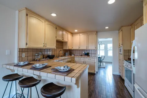 a kitchen with a table chairs stove and kitchen island