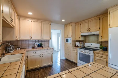 a kitchen with kitchen island granite countertop a sink cabinets and stainless steel appliances