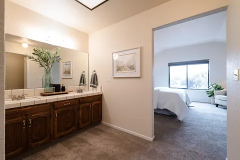 a spacious en suite bathroom with a double vanity sink tub and mirror
