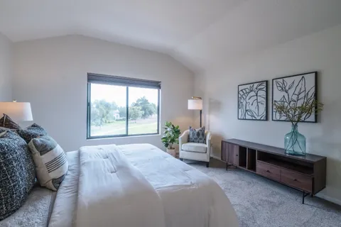 a spacious bedroom with a bed a couch and a window