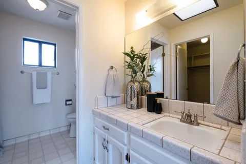 a bathroom with a granite countertop sink and a mirror