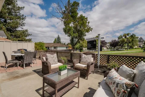 a roof deck with couches and potted plants