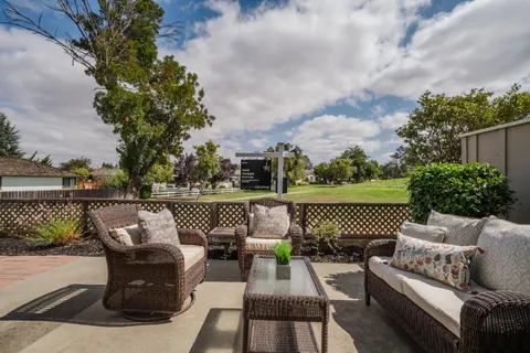 a view of a couch in the deck next to a lake