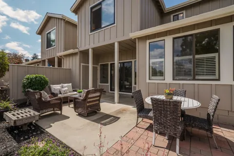 a view of a patio with couple of chairs and a potted plant