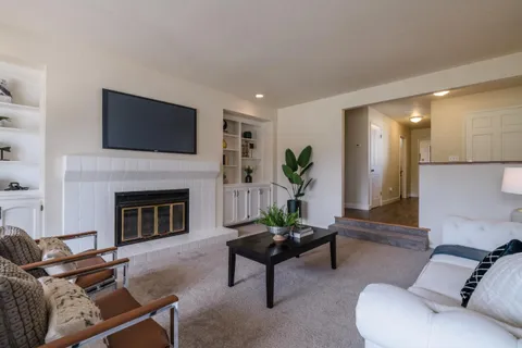 a living room with furniture a fireplace and a flat screen tv