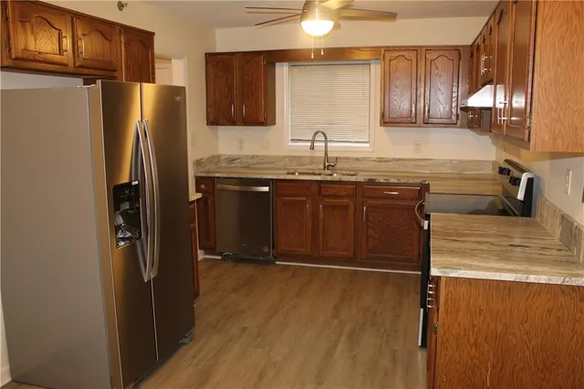 a kitchen with stainless steel appliances granite countertop a refrigerator and a sink