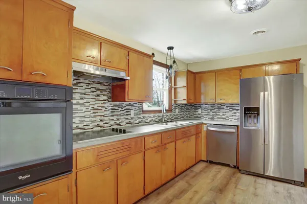 a kitchen with stainless steel appliances granite countertop a refrigerator and a sink