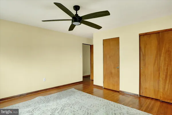 a view of a big room with wooden floor and a ceiling fan