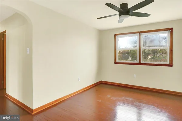 an empty room with a window and a ceiling fan