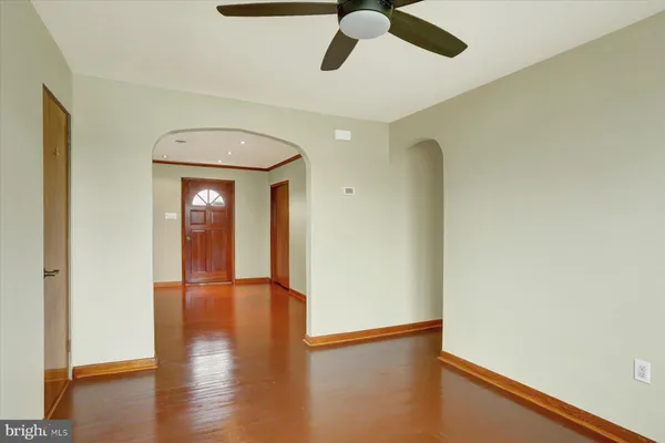 an empty room with wooden floor closet and windows