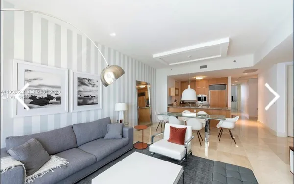 a living room with furniture a flat screen tv and a large window