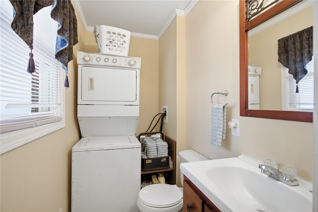 108 Hodge Street Abbeville, SC 29620 - Photo 17 of 39 A well-appointed utility area featuring stacked laundry appliances and a convenient half-bath setup.