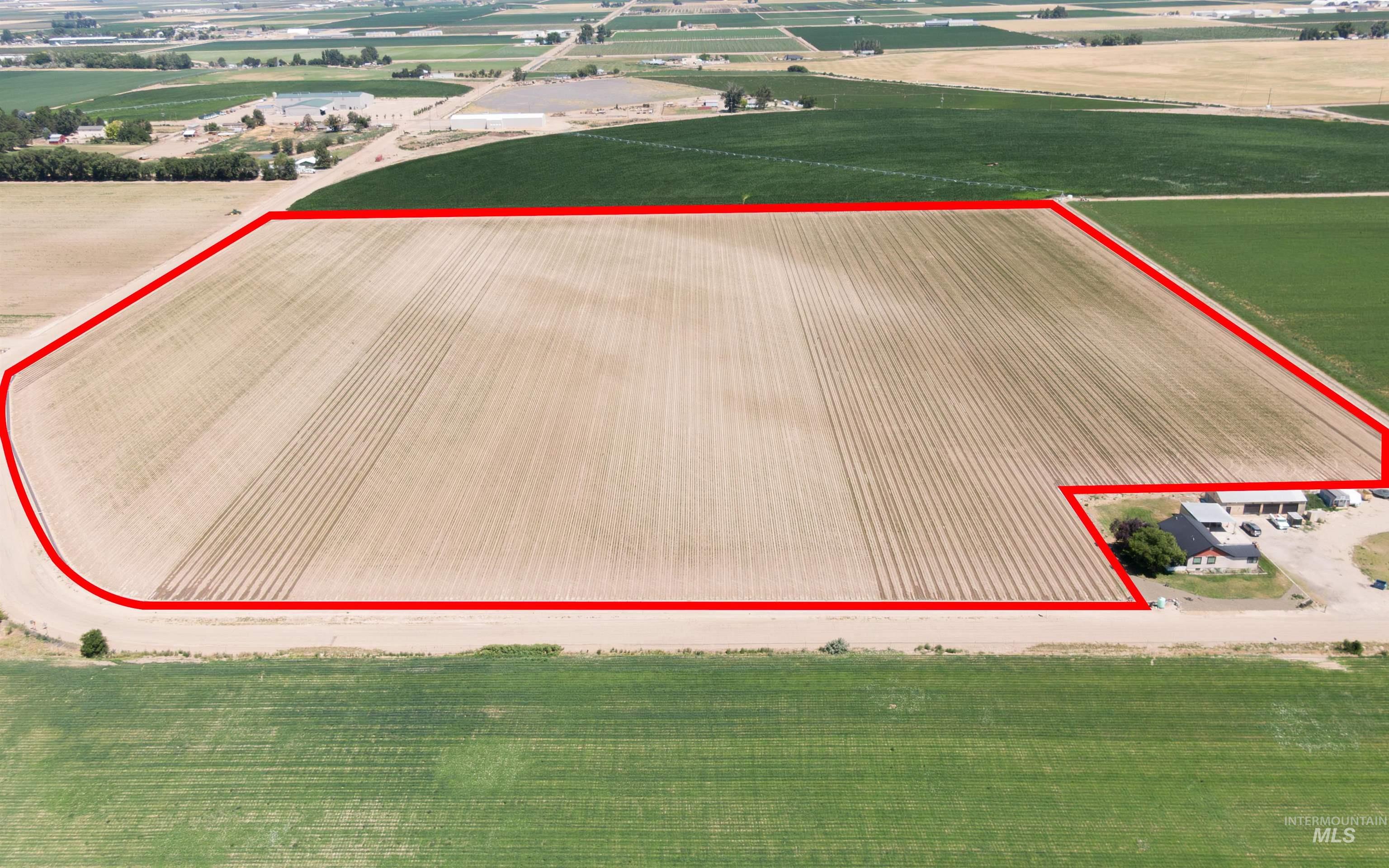 Aerial view of sparsely populated area featuring rows of crops and property boundaries highlighted