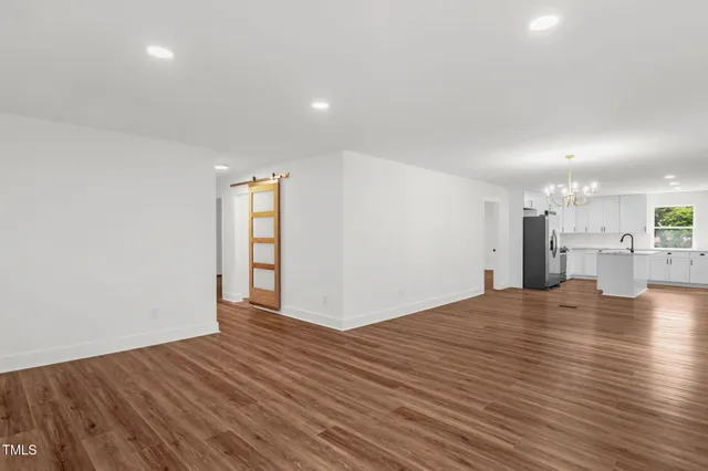 a view of a kitchen with wooden floor and a window