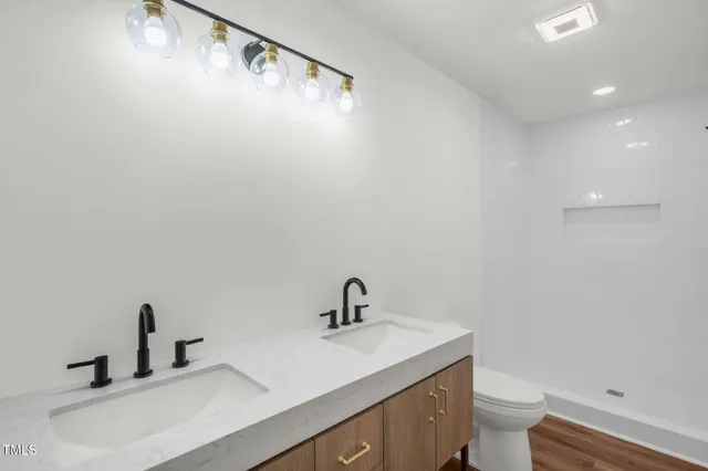 a bathroom with a sink a toilet and a mirror