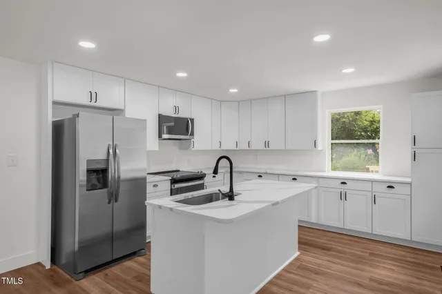a kitchen that has a sink cabinets counter space and stainless steel appliances