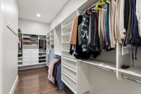 a view of walk in closet with clothes and shoes