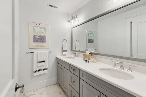 a bathroom with a double vanity sink and a mirror