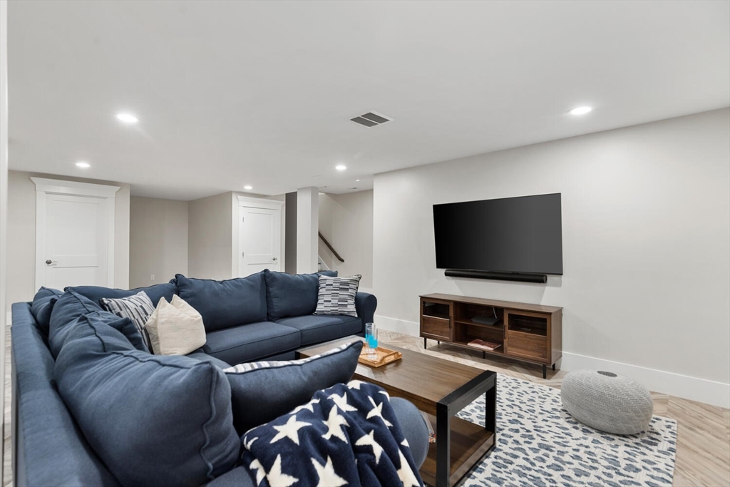 19 Gershon Way, Unit 1 Winchester, MA 01890 - Photo 39 of 42 a living room with furniture and a flat screen tv