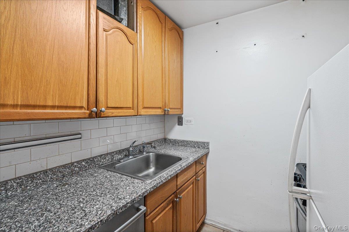 17-85 215th Street, Unit 5L Queens, NY 11360 - Photo 14 of 46 a kitchen with a sink a stove and cabinets