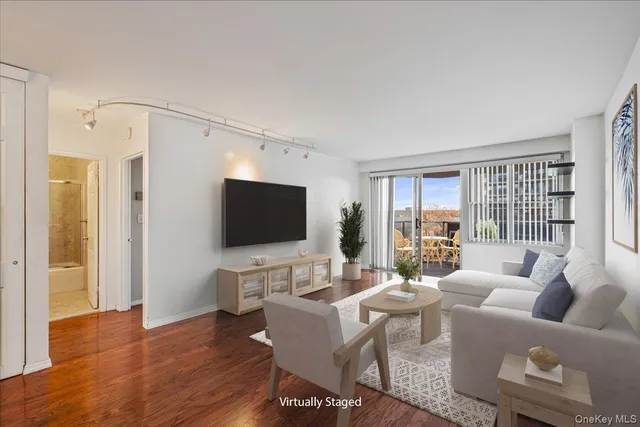 a living room with furniture a flat screen tv and a large window