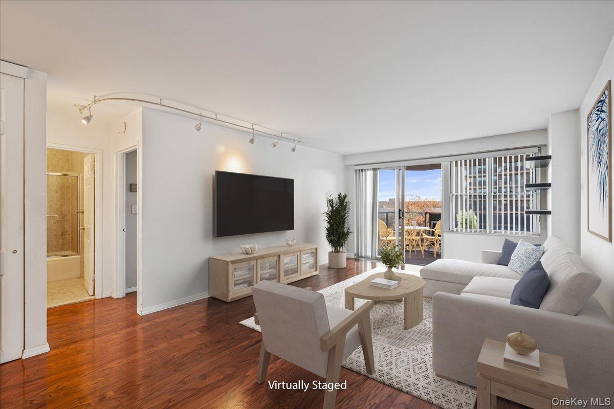 17-85 215th Street, Unit 5L Queens, NY 11360 - Photo 3 of 46 a living room with furniture a flat screen tv and a large window