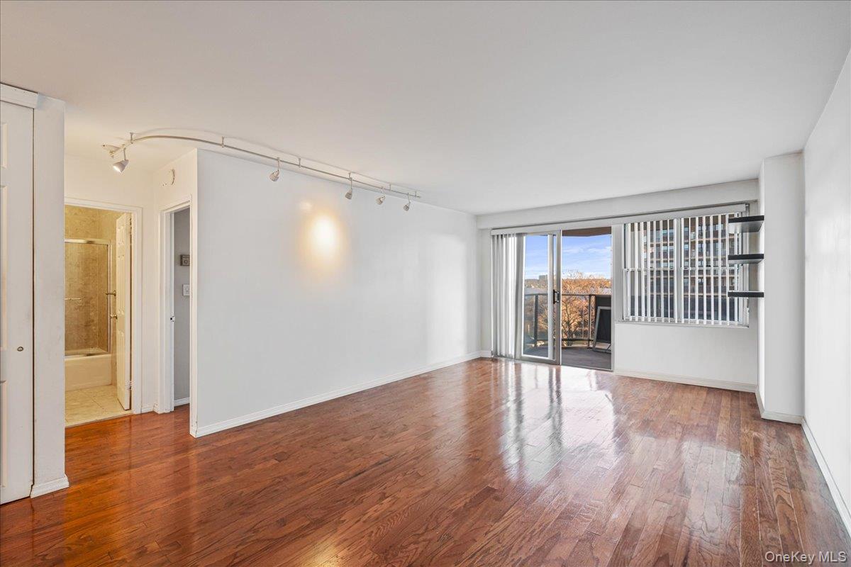 17-85 215th Street, Unit 5L Queens, NY 11360 - Photo 5 of 46 a view of an empty room with wooden floor and a window