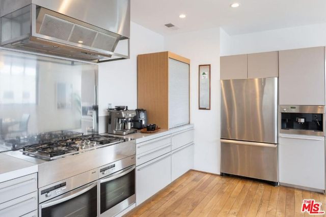a kitchen with stainless steel appliances granite countertop a refrigerator and a stove