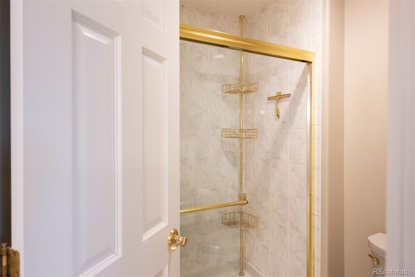 3935 Pierson Street Wheat Ridge, CO 80033 - Photo 28 of 50 a bathroom with a glass shower door