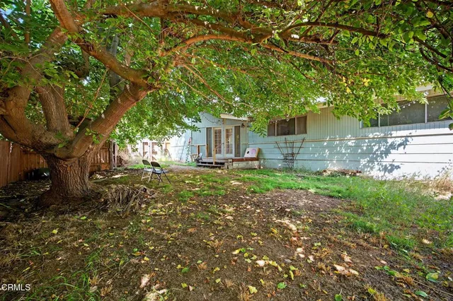 a backyard of a house with table and chairs