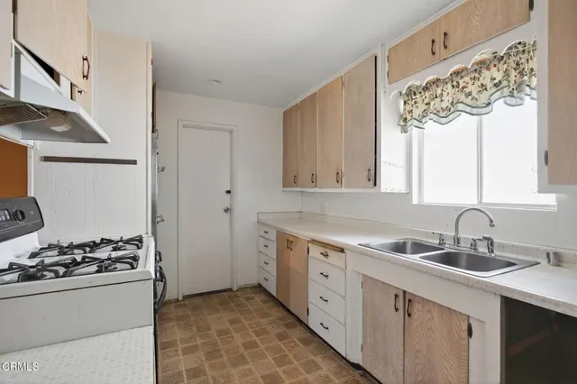 a kitchen with a stove sink and refrigerator