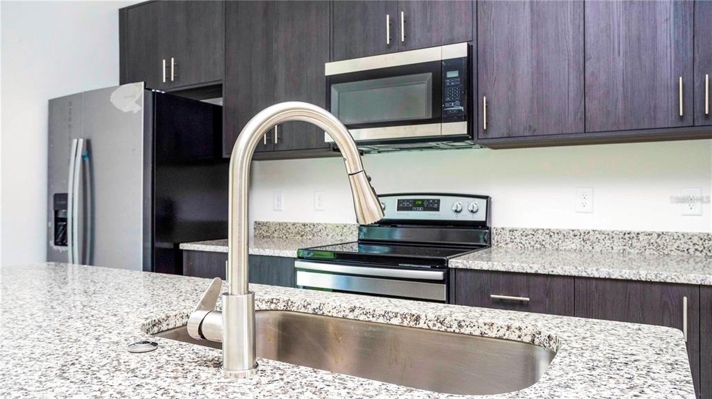 4147 Southwest 167th Street Ocala, FL 34473 - Photo 14 of 45 a kitchen with stainless steel appliances kitchen island a stove a sink and a microwave