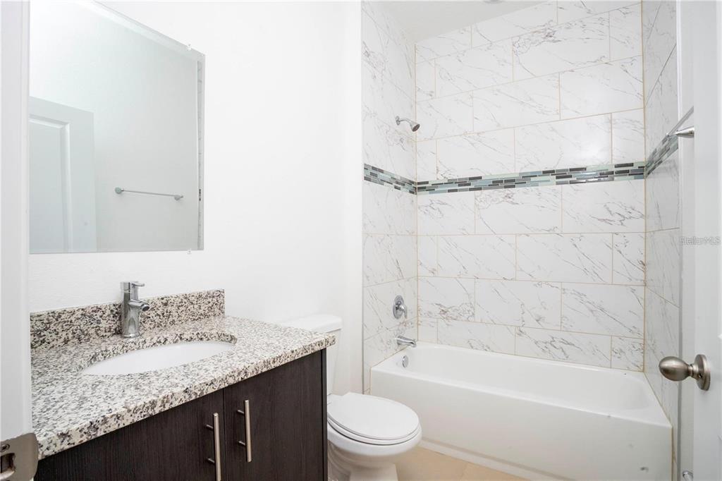 4147 Southwest 167th Street Ocala, FL 34473 - Photo 31 of 45 a bathroom with a granite countertop sink a toilet and shower