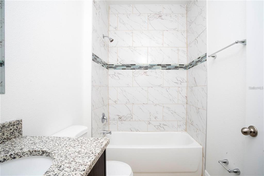 4147 Southwest 167th Street Ocala, FL 34473 - Photo 32 of 45 a bathroom with a granite countertop bathtub shower and toilet